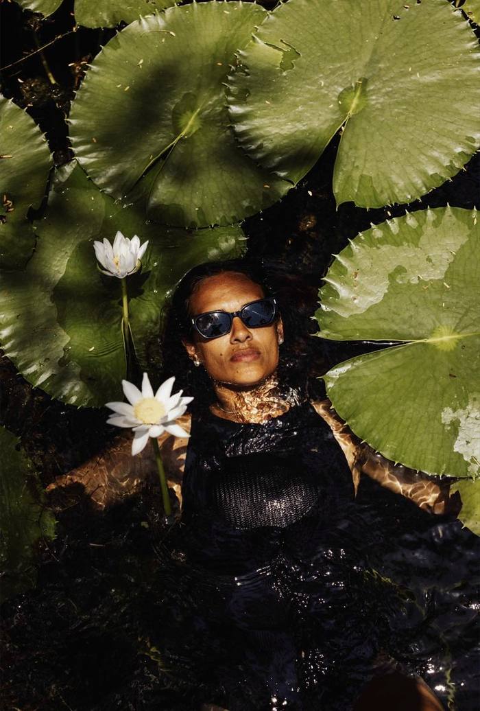 Otis sunglasses worn in a lily-covered billabong, water lilies and pads around.